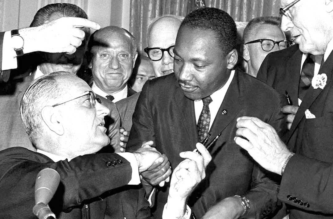 President Lyndon B. Johnson shakes hands with Dr. Martin Luther King Jr. at the signing of the Civil Rights Act of 1964